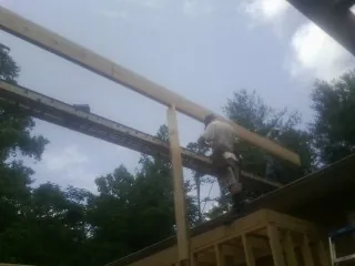 Carpenter setting a ridge beam over a new addition frame — Ice Dam Removal by Roofing Brothers in Starford