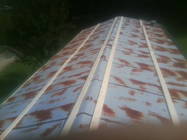 Rusted metal roof panels with new wood purlins before replacement — Storm Damage Roof Repair in Starford by Roofing Brothers