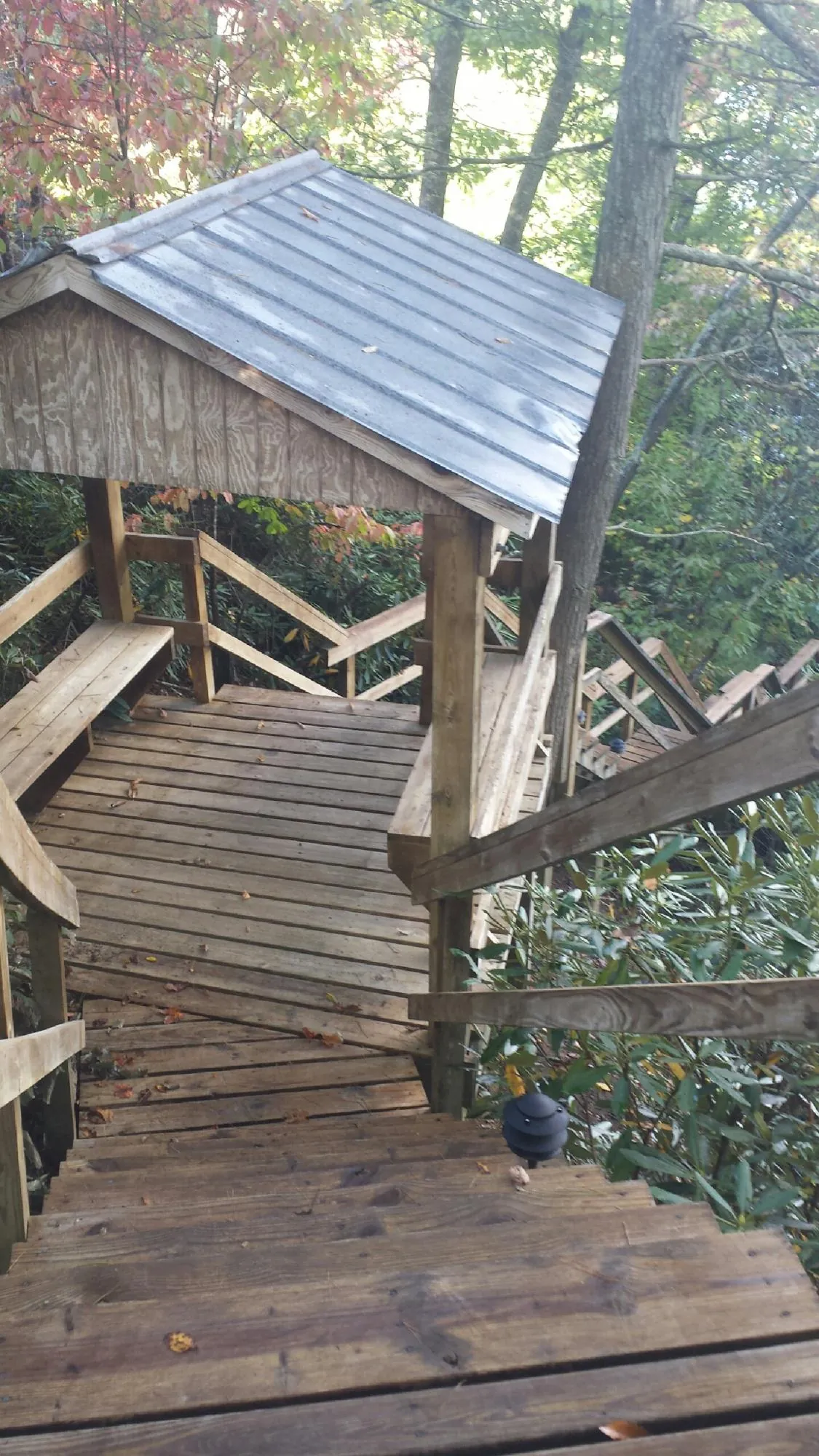 Metal roofed shelter over wooden steps on a wooded walkway — Skylight Repair & Installation work by our crew in Starford