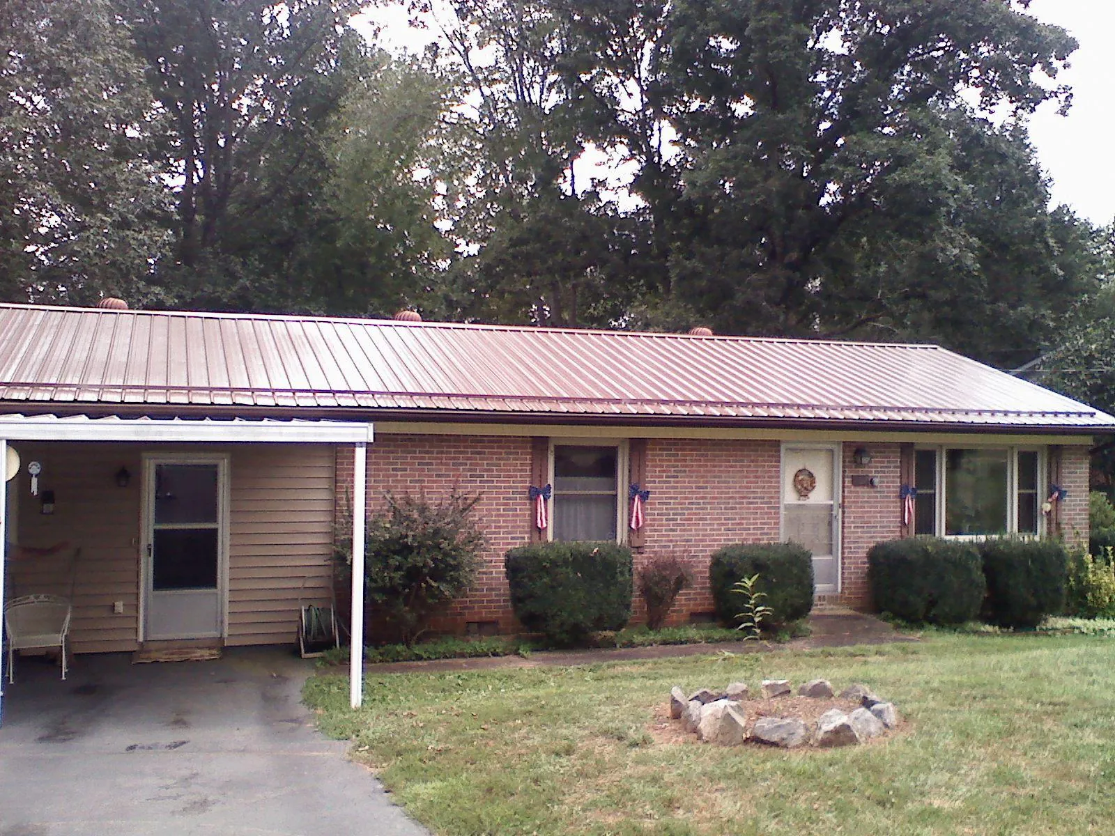 Bronze metal roof and carport on a brick ranch home — Roof Repair work by our crew in Starford